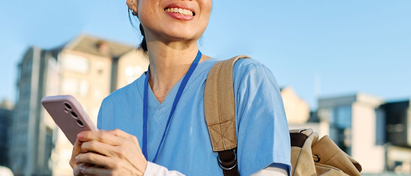 Infermiera in camice all'esterno di una moderna struttura medica