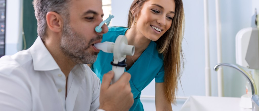 Spirometria di un uomo con dottoressa sullo sfondo