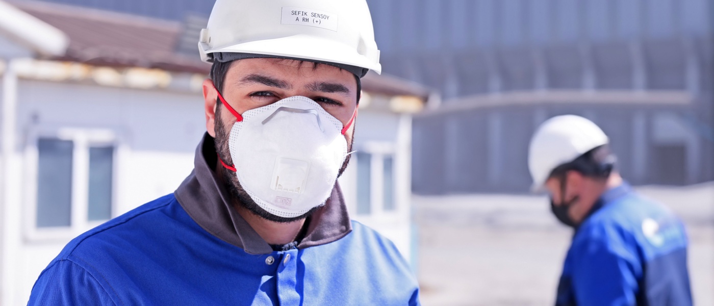 operaio che indossa una mascherina all'interno dello stabilimento