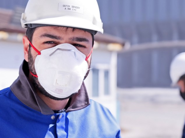 operaio che indossa una mascherina all'interno dello stabilimento
