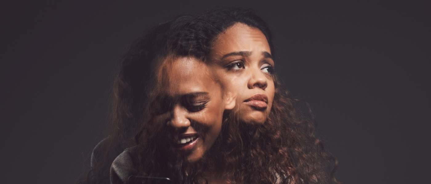 Depression, mental health and woman in studio with stress, identity crisis or bipolar disorder. Horror, psycho and female person with trauma or anxiety browsing on a phone by a dark black background.