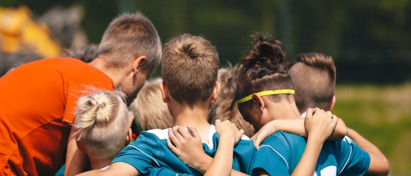 Giovane Squadra di Calcio Stringersi con Allenatore; Bambini in Allenamento Unità e Momento di Lavoro di Squadra