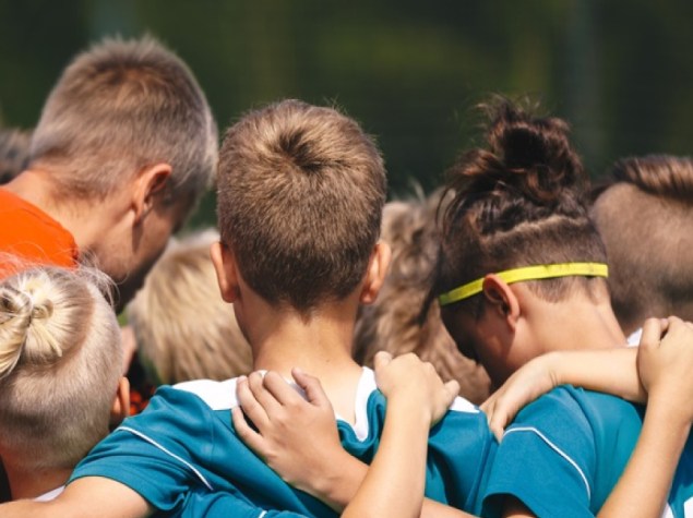 Giovane Squadra di Calcio Stringersi con Allenatore; Bambini in Allenamento Unità e Momento di Lavoro di Squadra